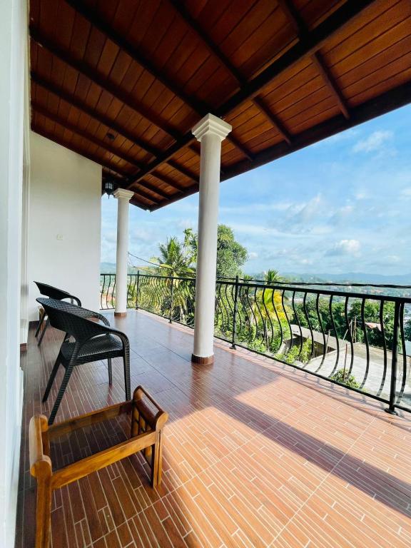 a balcony with a bench and a view of the ocean at Villa Avora Ridge in Kandy