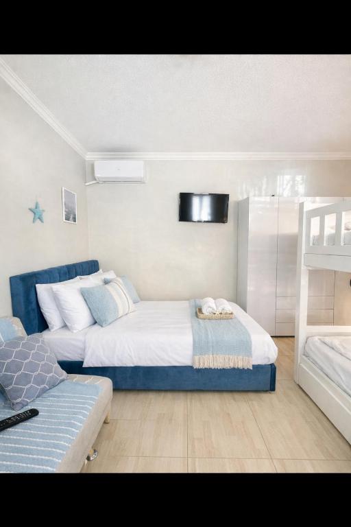 a bedroom with two beds and a couch at Ground floor Studio in Golem Next to Hotel Flower self check in 100m to beach in Golem