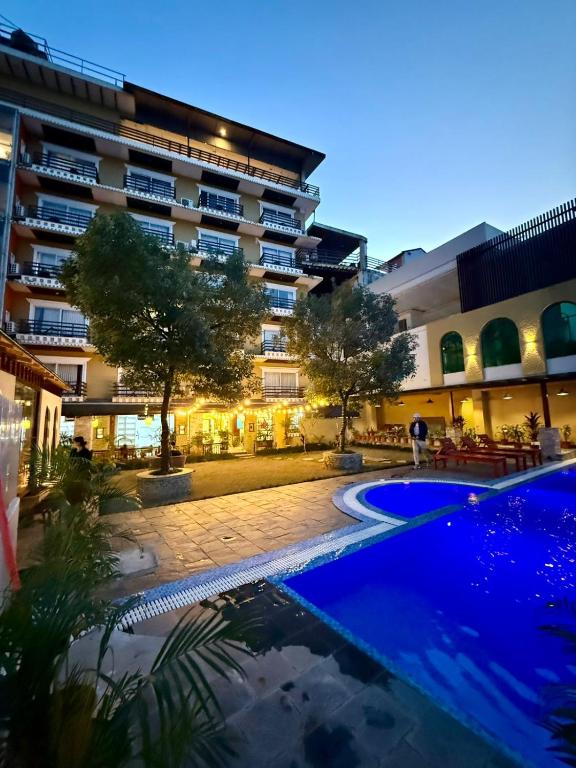 a hotel with a swimming pool in front of a building at Bodhi Suite Boutique Hotel & Wellness in Pokhara