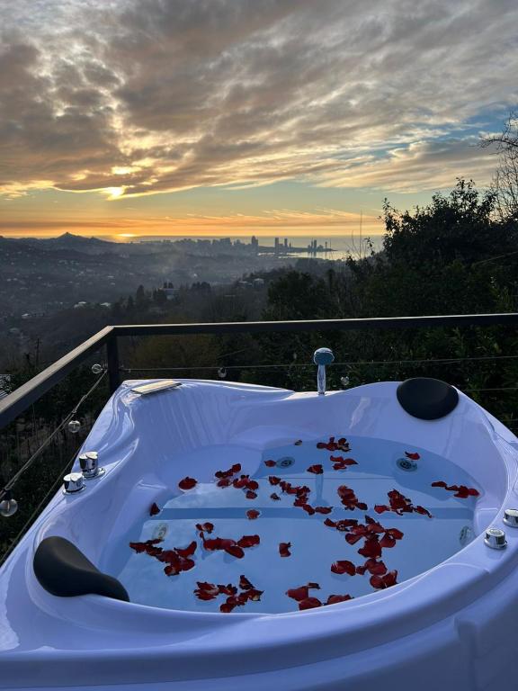 a hot tub sitting on the edge of a balcony at Orange Cottage in Agara