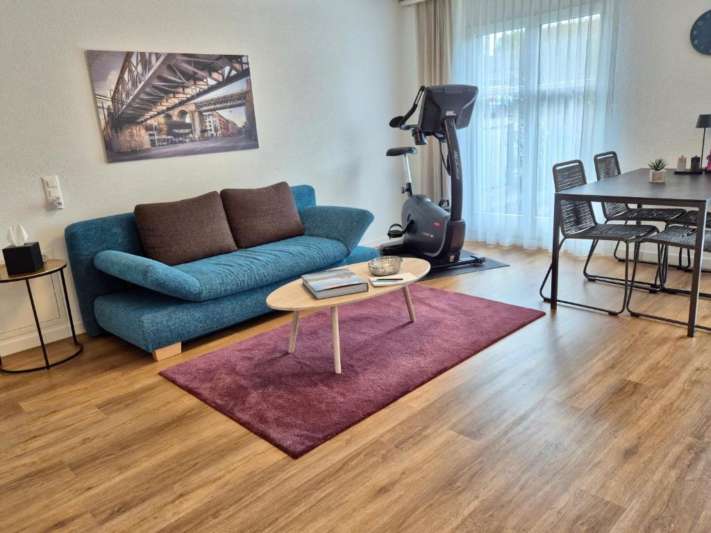 a living room with a blue couch and a table at Stilvolles Wohnen an der Goldküste, nahe Zürich - 55m2 in Erlenbach