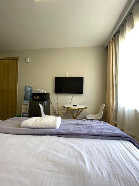 a bedroom with a large bed with a flat screen tv at Staunch Homes Luxury Studio Apartment in Nairobi