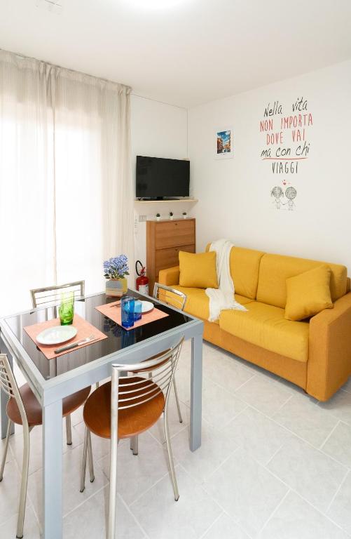a living room with a yellow couch and a table at Dimora del Mare in Isola Bacucco