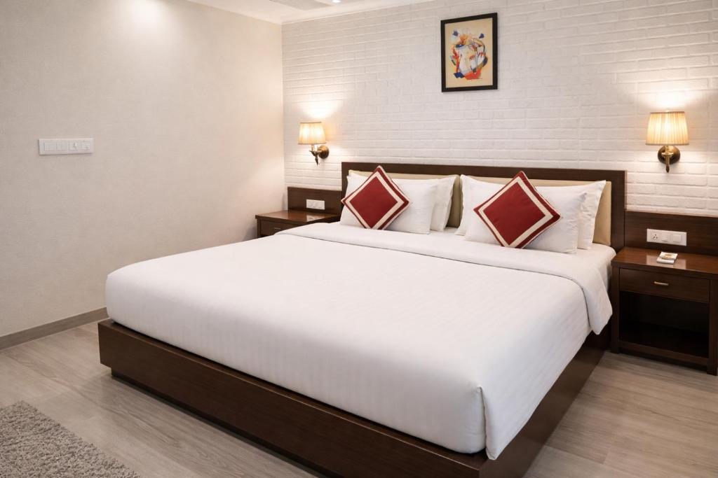 a bedroom with a large white bed and two night stands at Hotel Diplomat Residency in Bareilly