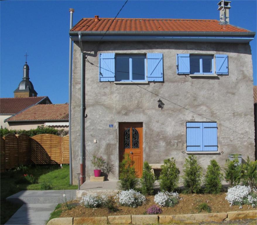 una casa con una puerta naranja y ventanas azules en Gite la ruche, en Senon