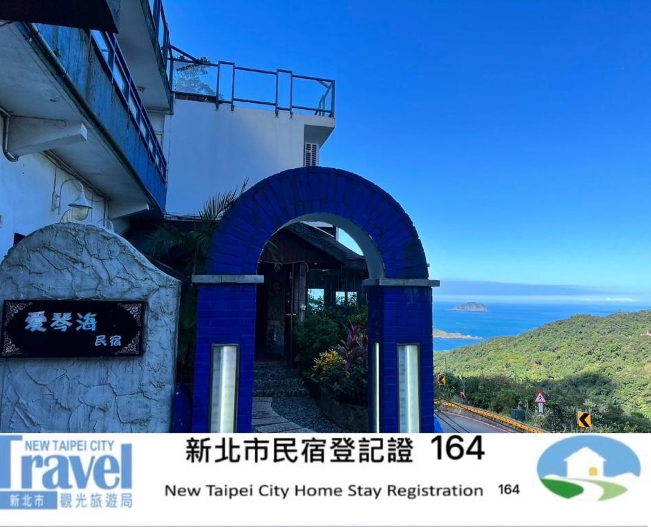 a building with a blue archway next to the ocean at Aegean Sea Guest House in Jiufen