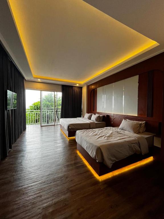 a hotel room with two beds and a balcony at Stone Valley Resort & Beach in Tepus