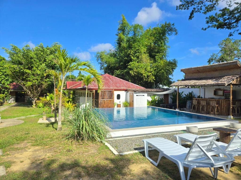 a villa with a swimming pool and a house at Masayana in El Nido