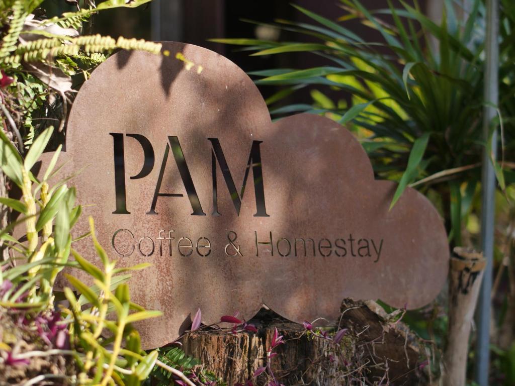 a sign for panu coffee and homesay in a garden at Pam Hill in Bản Pha Xum