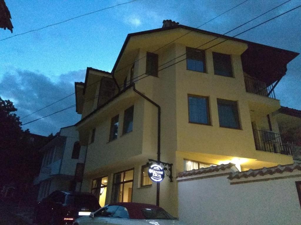 a large yellow building with a sign in front of it at Roots Hotel Old Town in Plovdiv