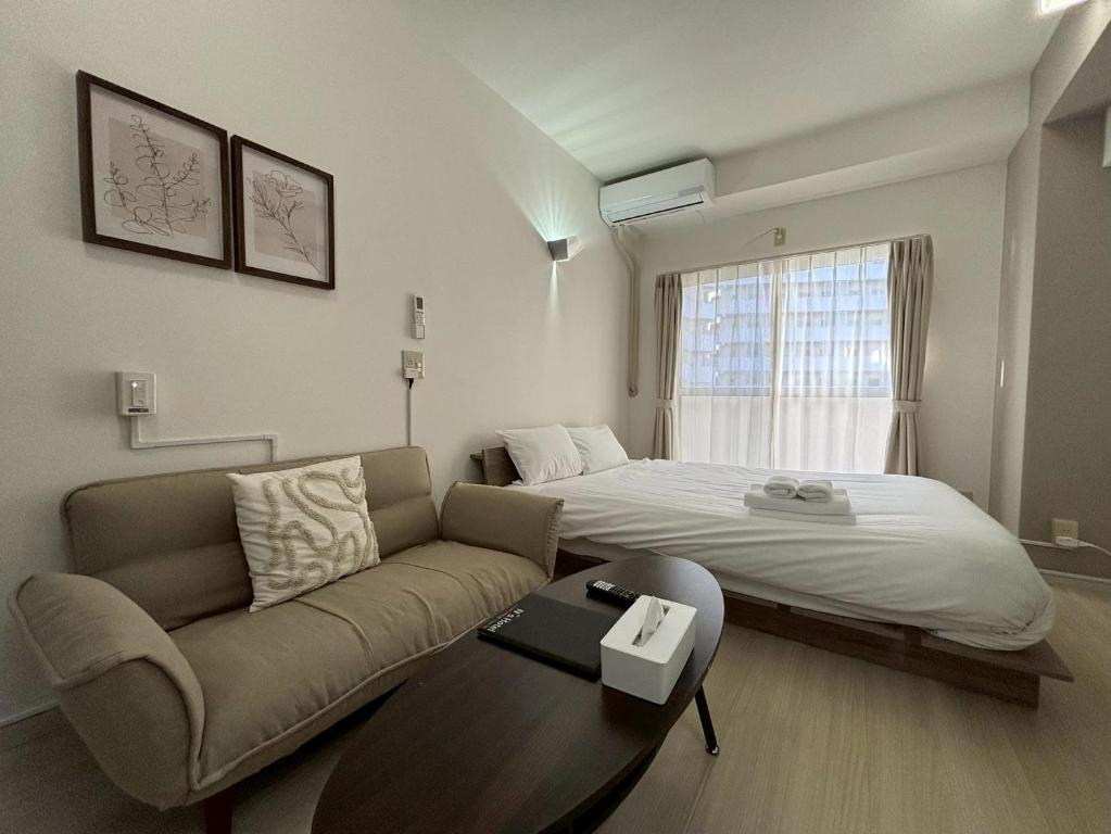 a living room with a couch and a bed at N's Hotel 平和公園 in Hiroshima