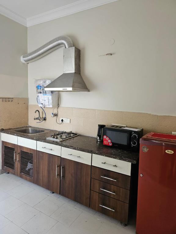 a kitchen with a stove and a sink and a microwave at Silver Oak Mansion in Jalandhar