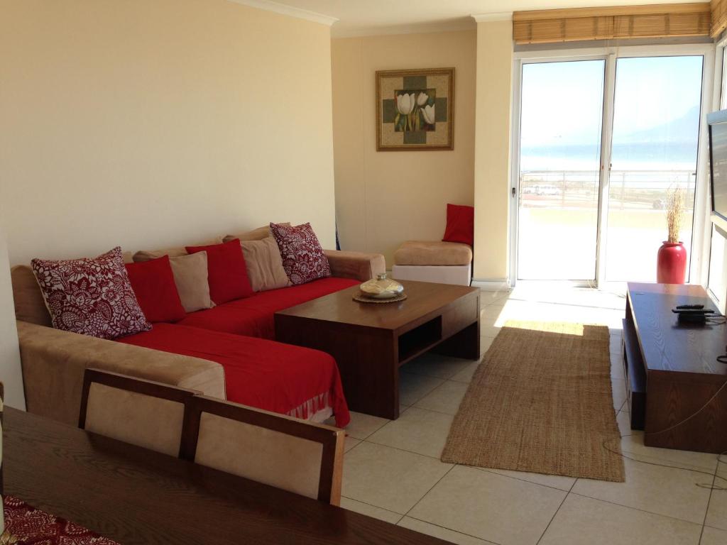 a living room with a couch and a table at Portico 203 in Bloubergstrand