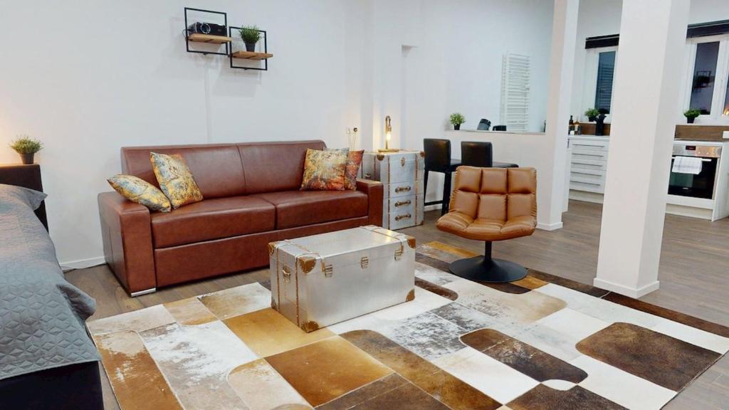 a living room with a couch and a chair at Wohnung mit Heimkino mitten in der Altstadt in Celle