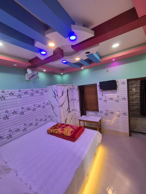 a room with a bed and a tv in it at New suvam lodge & hotel in mayapur