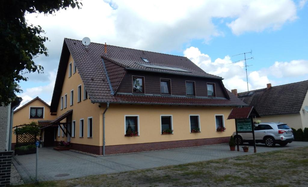 a yellow house with a black roof at Spreewald-Pension Marina in Lübben