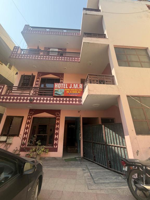 a building with a car parked in front of it at Hotel JMR in Sohāna