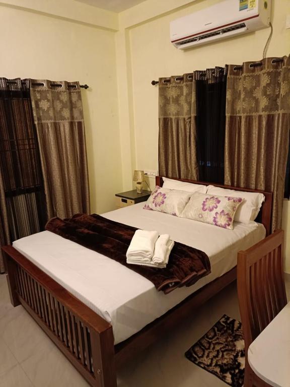 a bedroom with a bed with two towels on it at Godiva Homestay in Cochin
