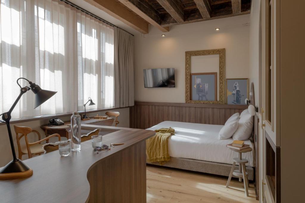 a bedroom with a bed and a desk with a mirror at Académie Hôtel Lyon in Lyon