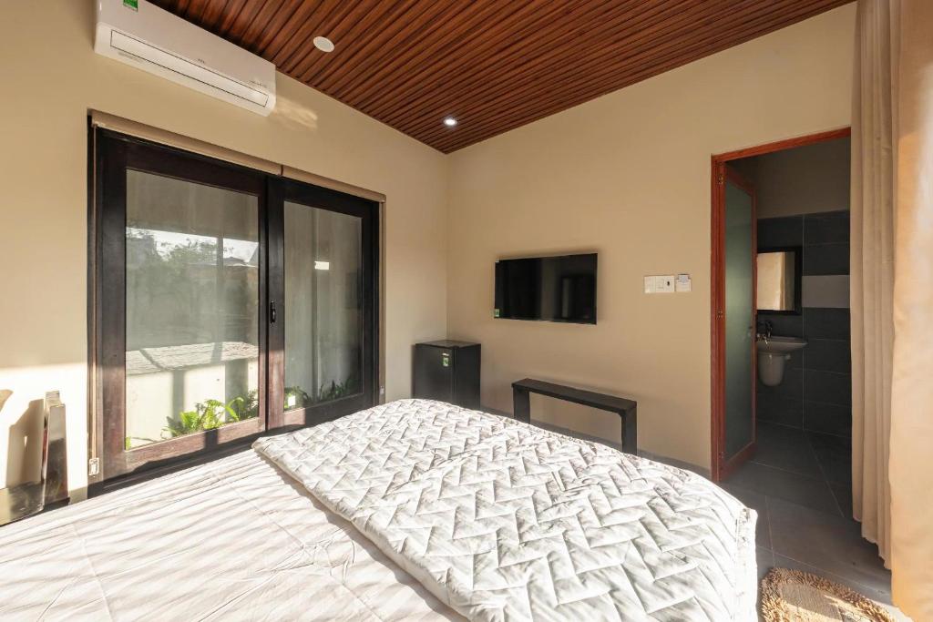 a bedroom with a bed and a large window at Homestay coffee Hoàng Nhạn in Mỹ Hòa (1)