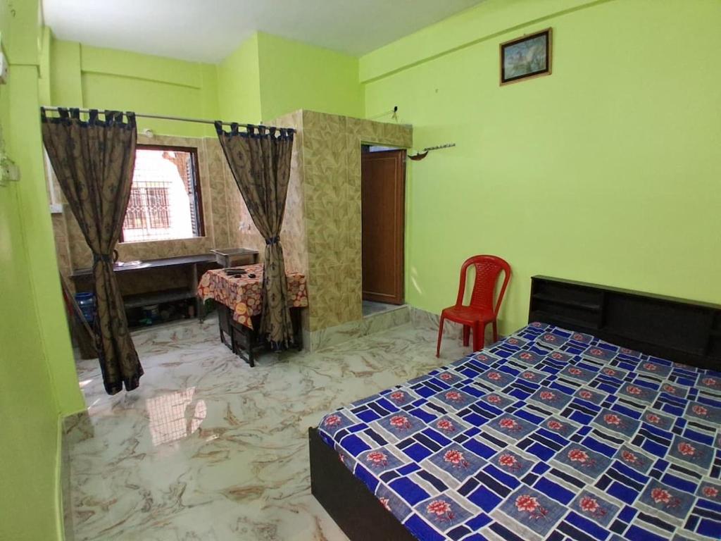 a bedroom with a bed and a desk and a window at Comfort Studio Type Appartment - Kolkata in Nager Bazaar