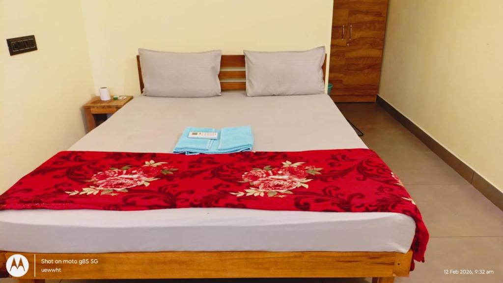 a bed with a red blanket on top of it at The Haira Retreat in Kappil