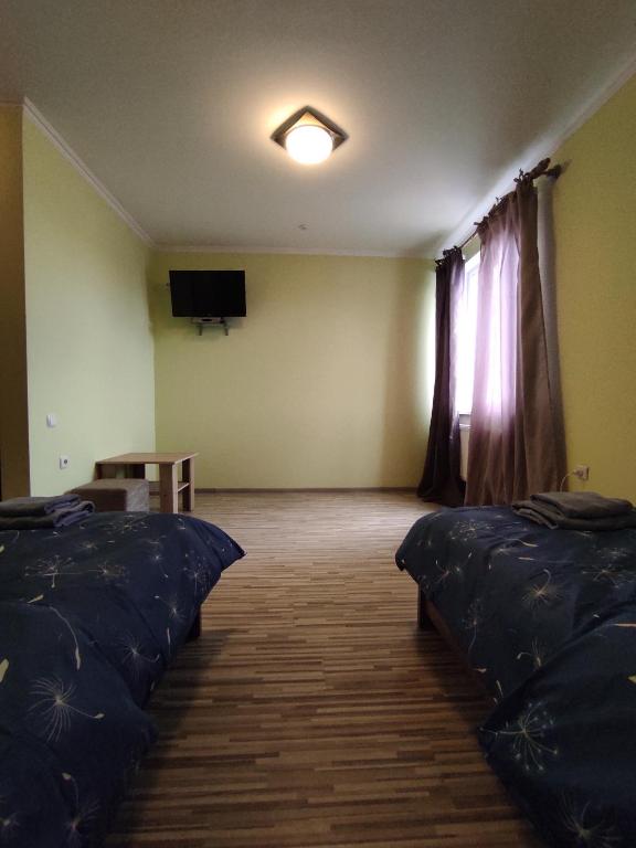 a room with two beds and a flat screen tv at Motel M19 in Lipiny