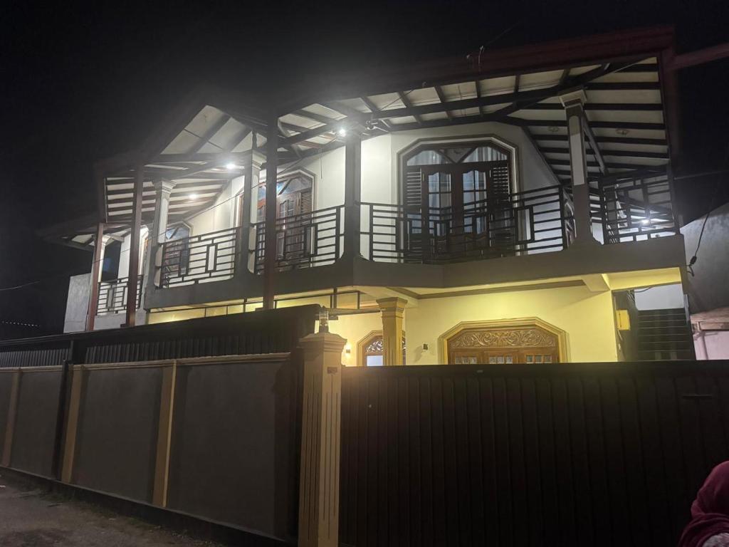 a house with a balcony on top of it at night at Aamy Luxury Villa in Galle
