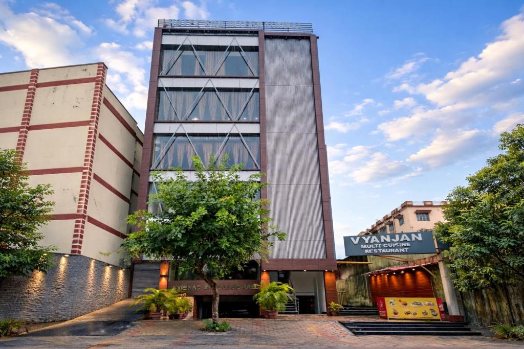 a tall building with a tree in front of it at New Sun International & Banquet Hall in Jamshedpur