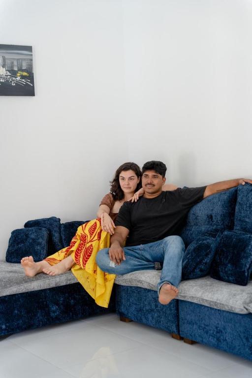a man and woman sitting on a blue couch at Villa Bee in Wennappuwa