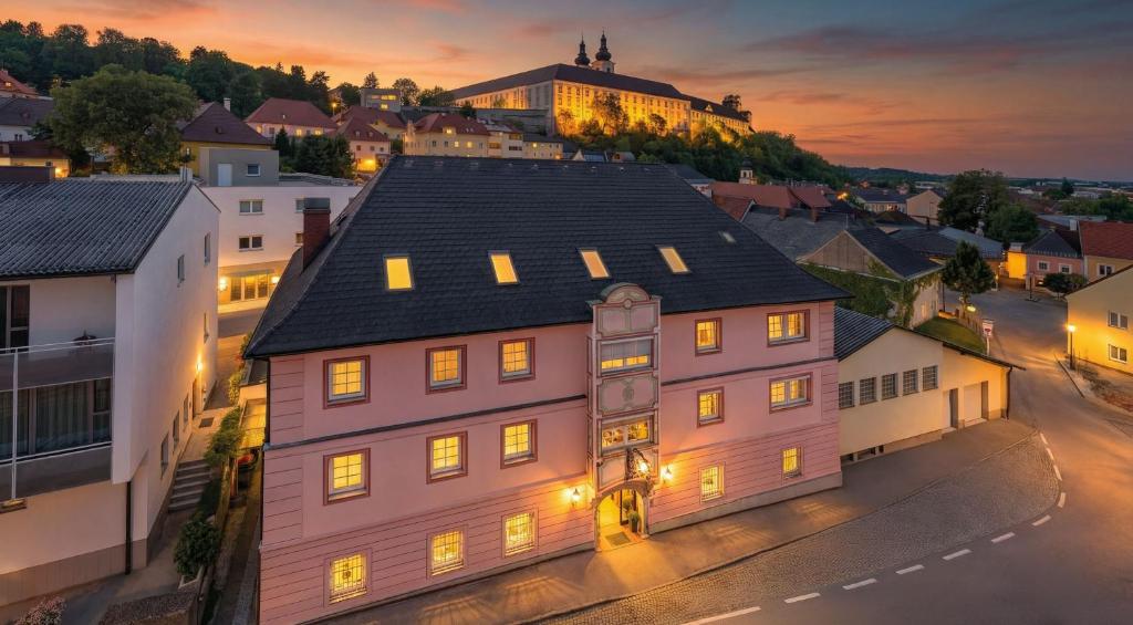 a large building in a town at night at Hotel Schlair in Kremsmünster
