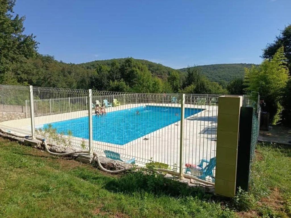a fence around a swimming pool in a field at Camping 3 étoiles - Piscine - ccbfeb0 in Mayrac