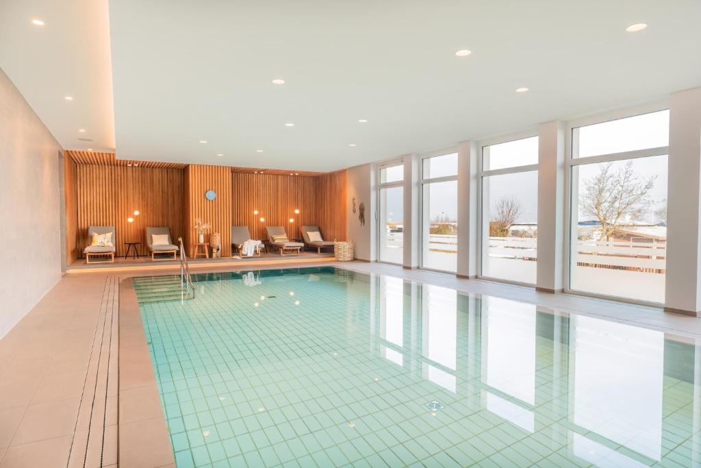 una grande piscina in una stanza con finestre di Hotel Strandhus a Cuxhaven