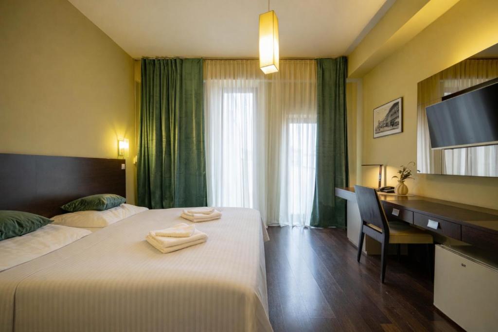 a hotel room with two beds and a desk and a television at AR Golden House II in Košice