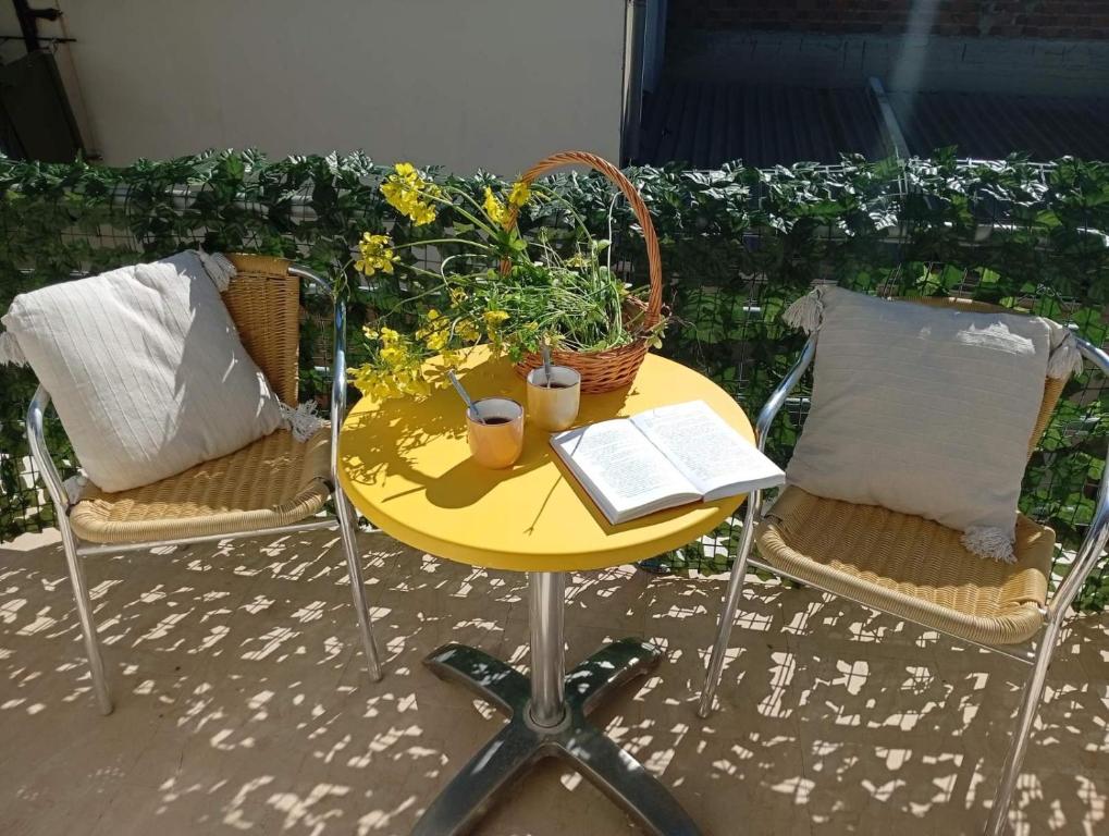 a yellow table and chairs with a book on it at on the STRIP studio 3 in Kavos