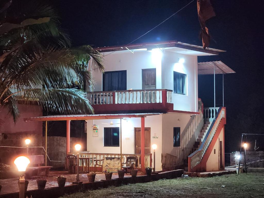 a large white house with a balcony at night at Serene Green Park in Canacona