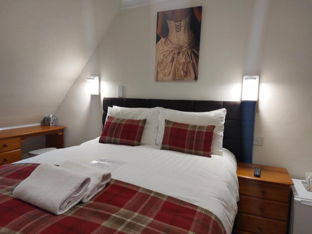 a bedroom with a large bed with two pillows at The Norwood in Torquay