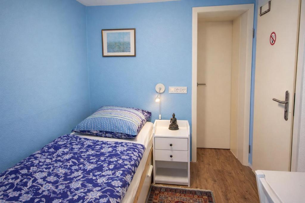 a bedroom with blue walls and a bed and a nightstand at Kleine Wohnung für Singles in Daun