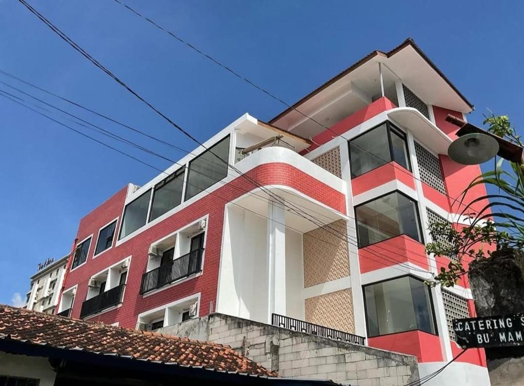 a red and white building on the side of a street at Grownicle Living Syariah in Yogyakarta
