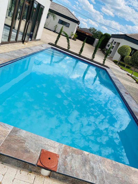 a large blue swimming pool in front of a house at Styled bed and breakfast in Palatswe