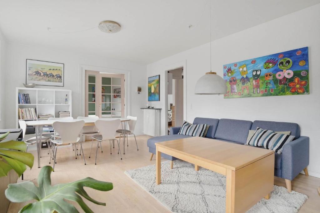 a living room with a blue couch and a table at Apartment in central Holstebro in Holstebro
