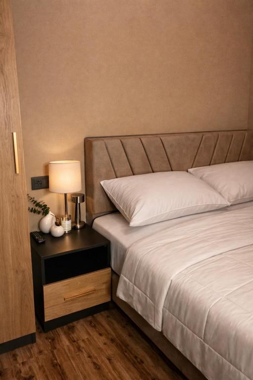 a bedroom with a bed and a table with a lamp at Republic Square In Hotel California in Yerevan