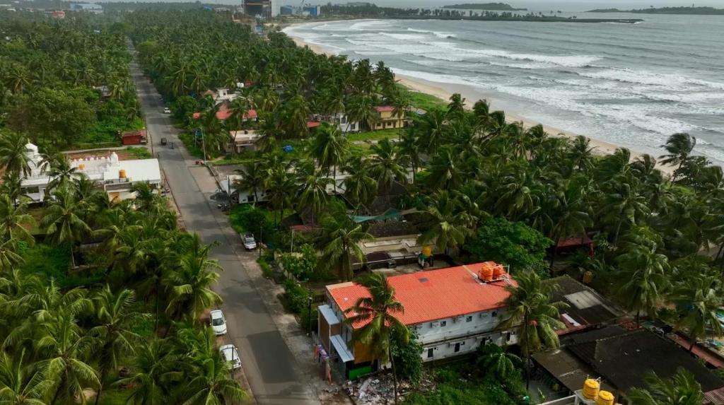 an aerial view of a beach with palm trees at Kanasu Residency Malpe in Udupi