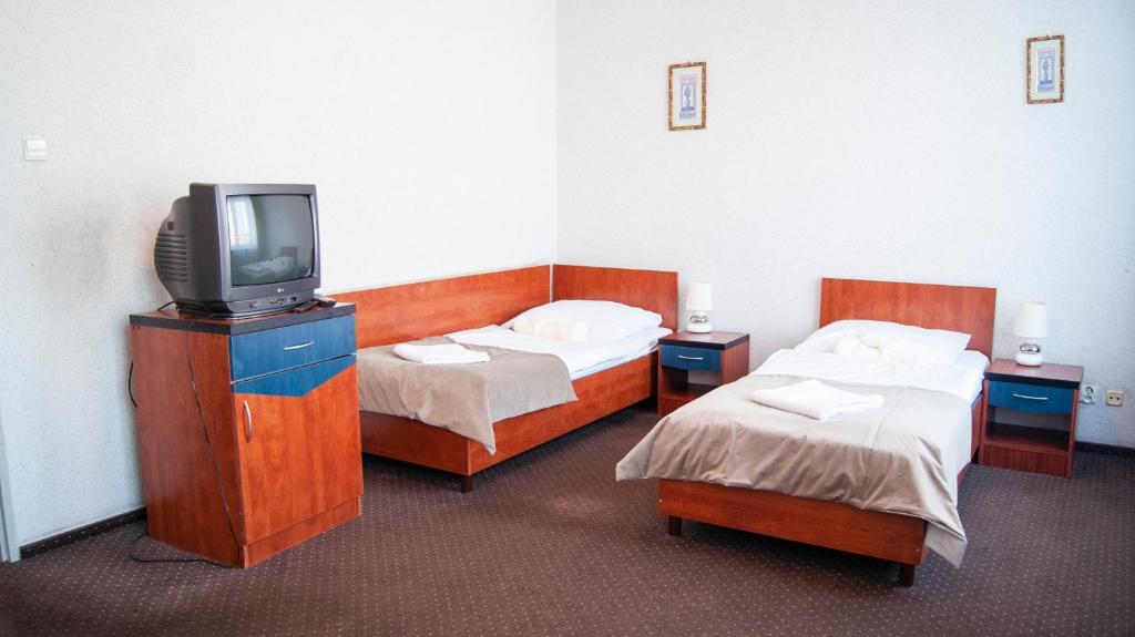 a hotel room with two beds and a tv at Zajazd Przy Granicy in Słuczanka