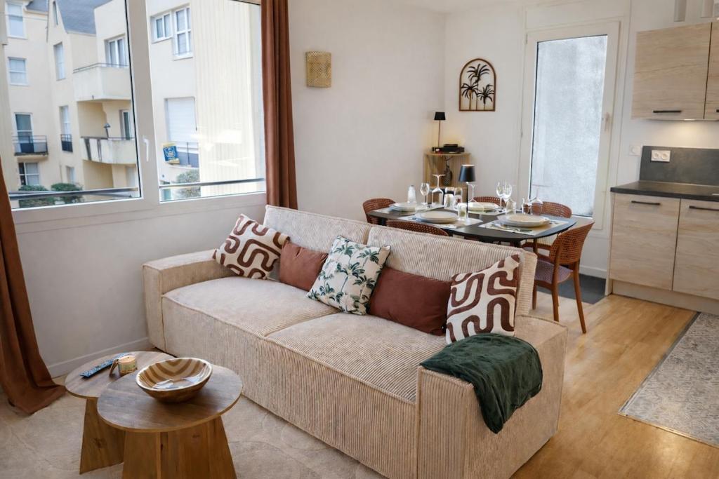 a living room with a couch and a table at Appartement hyper Centre Rénové Terrasse & Parking in Tours