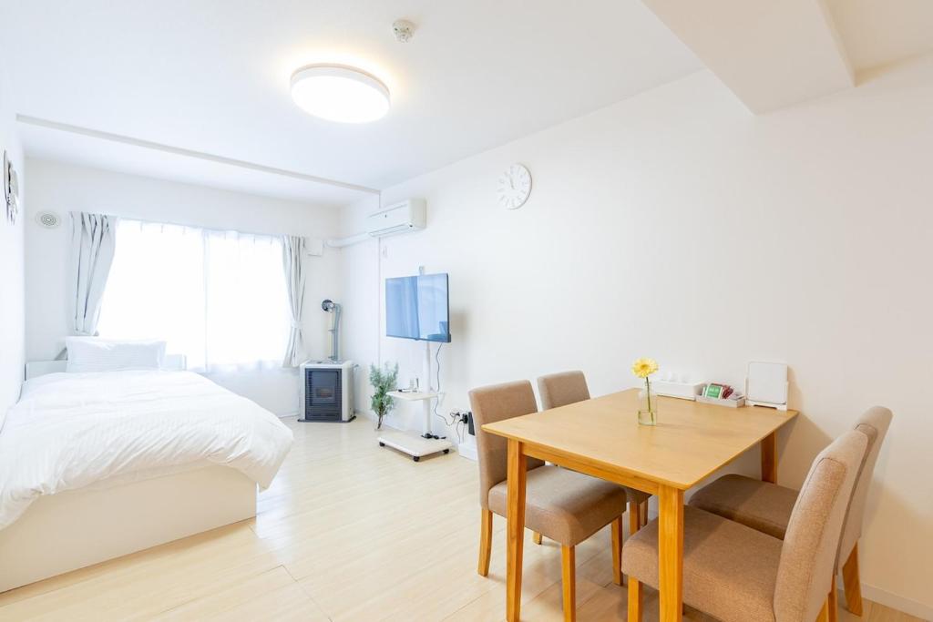 a bedroom with a table and a bed and a desk at mks102 in Sapporo