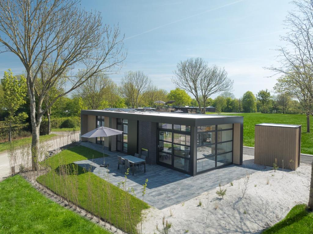 a modular home with a table and an umbrella at Villa Meerzicht | 4 Pers. in Workum