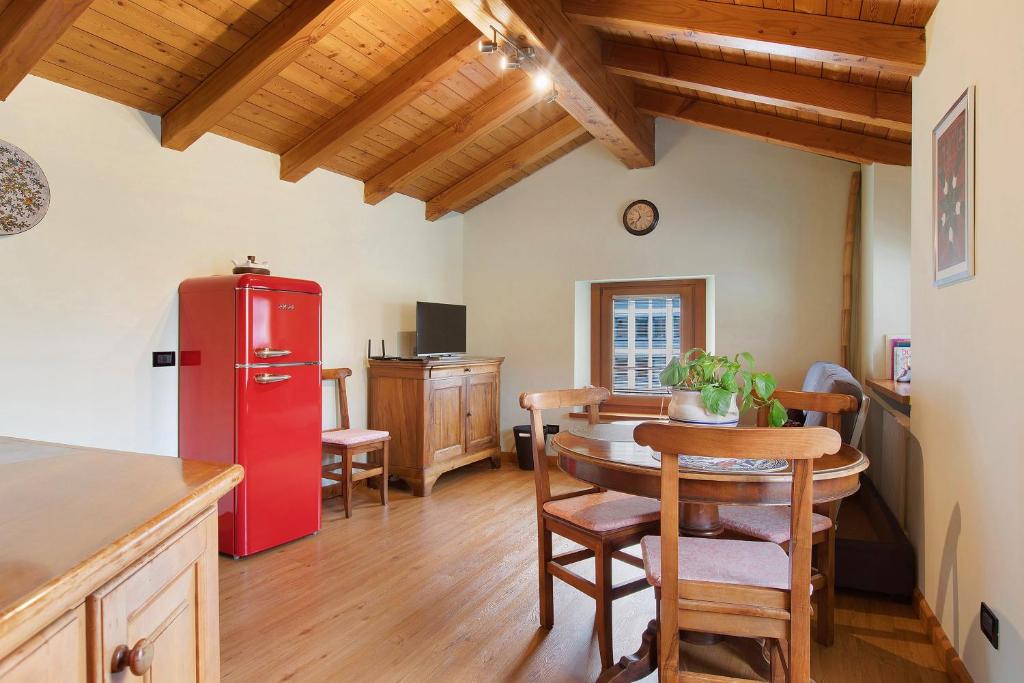 a kitchen with a red refrigerator and a table at La Mansardina - Aosta in Aosta
