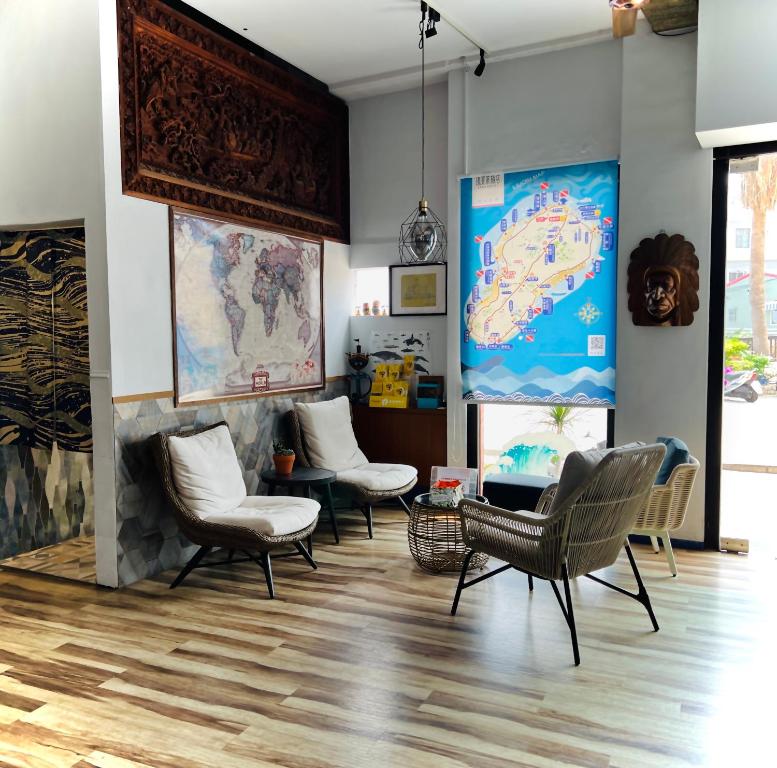 a living room with chairs and a map on the wall at Stay Hotel in Xiaoliuqiu