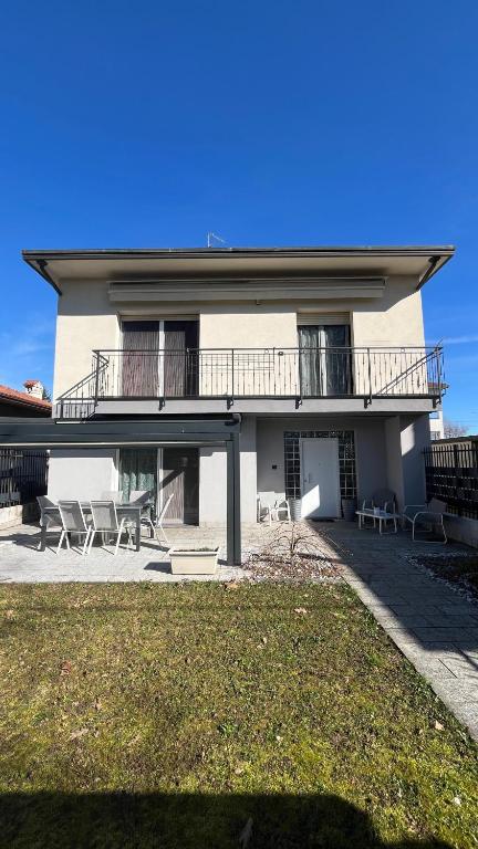 a white house with chairs and a balcony at B&b cuore di casa in Ferno